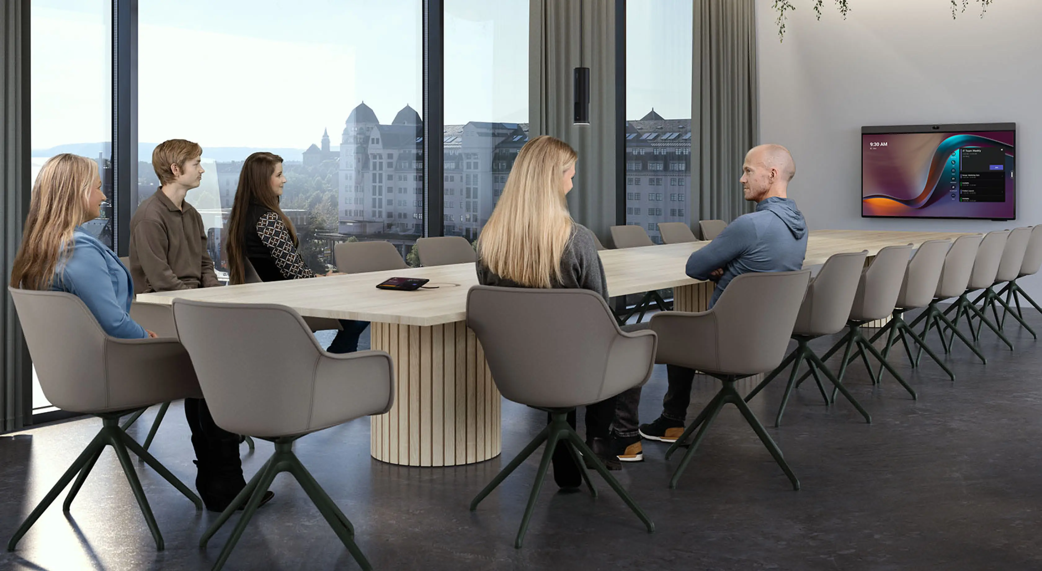 People in a meeting in a large meeting space equipped with Neat Bar Pro, Neat Center, and Neat Pad.