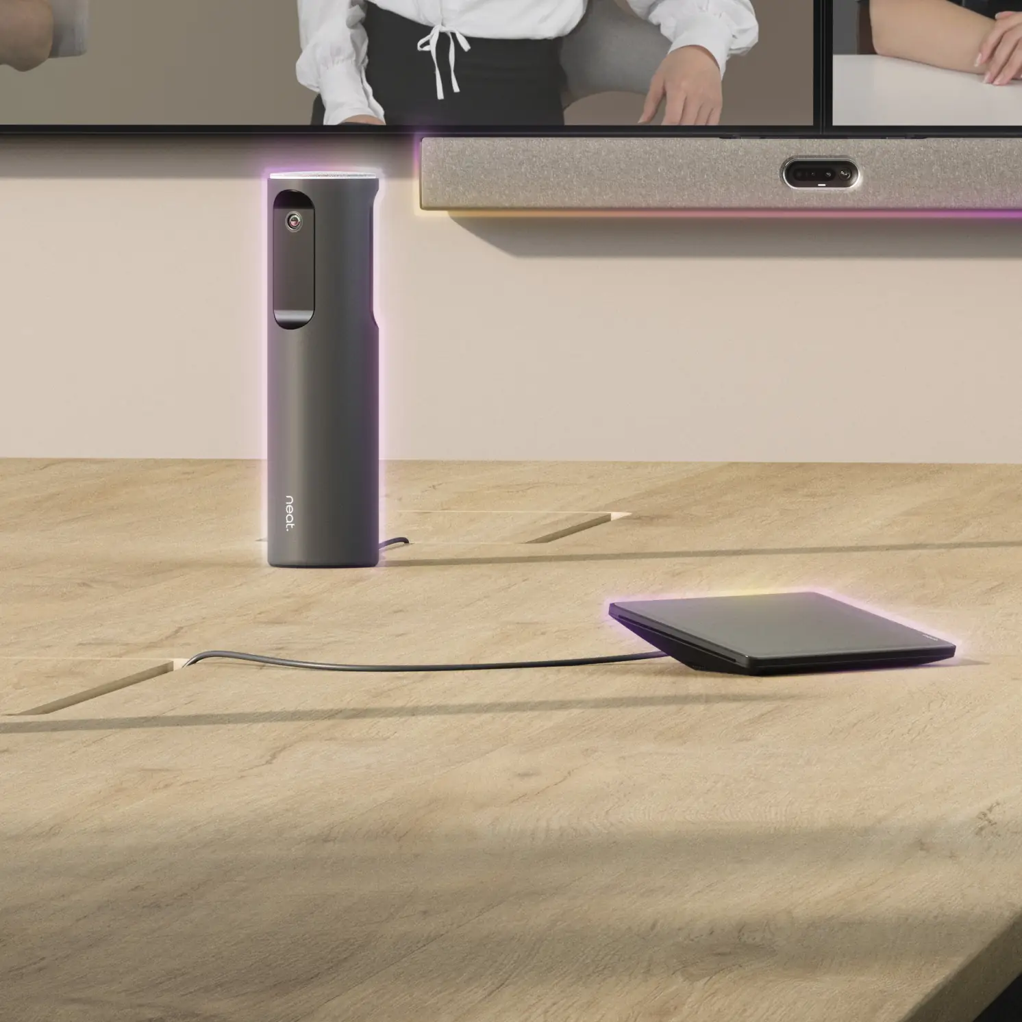 People in a meeting in a large meeting space equipped with Neat Bar Pro, Neat Center, and Neat Pad.
