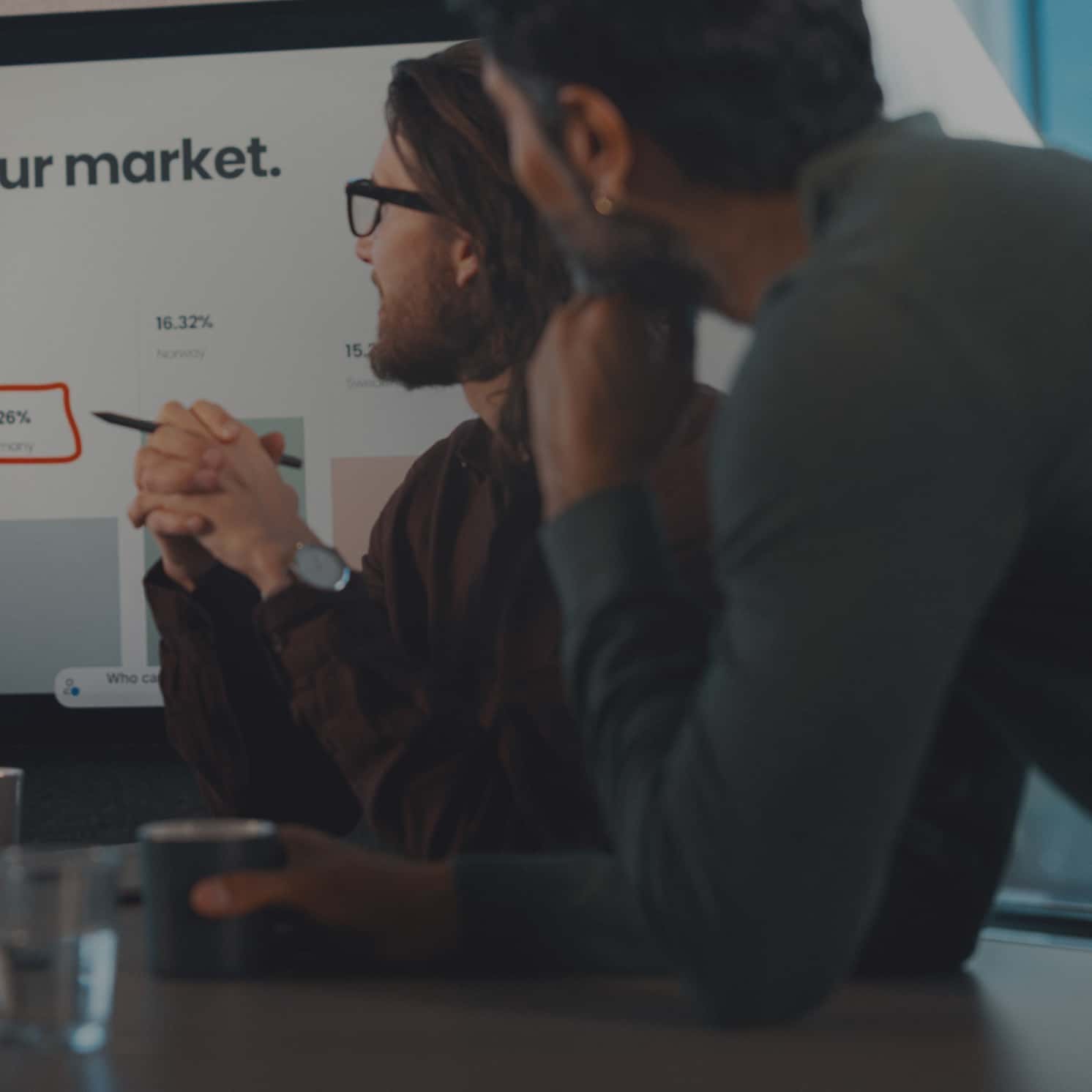 People in a meeting in a large meeting space equipped with Neat Bar Pro, Neat Center, and Neat Pad.